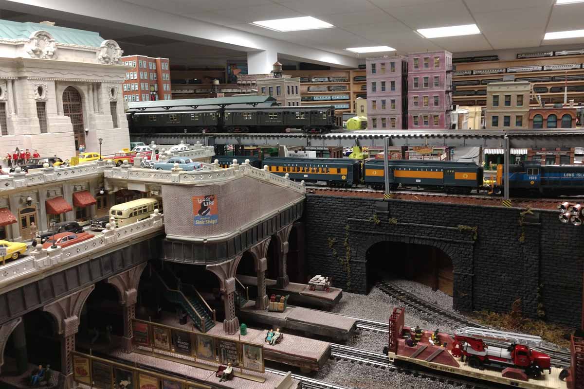 deadhead railways - 0 gauge trains - view of city with a bunch of building in background
